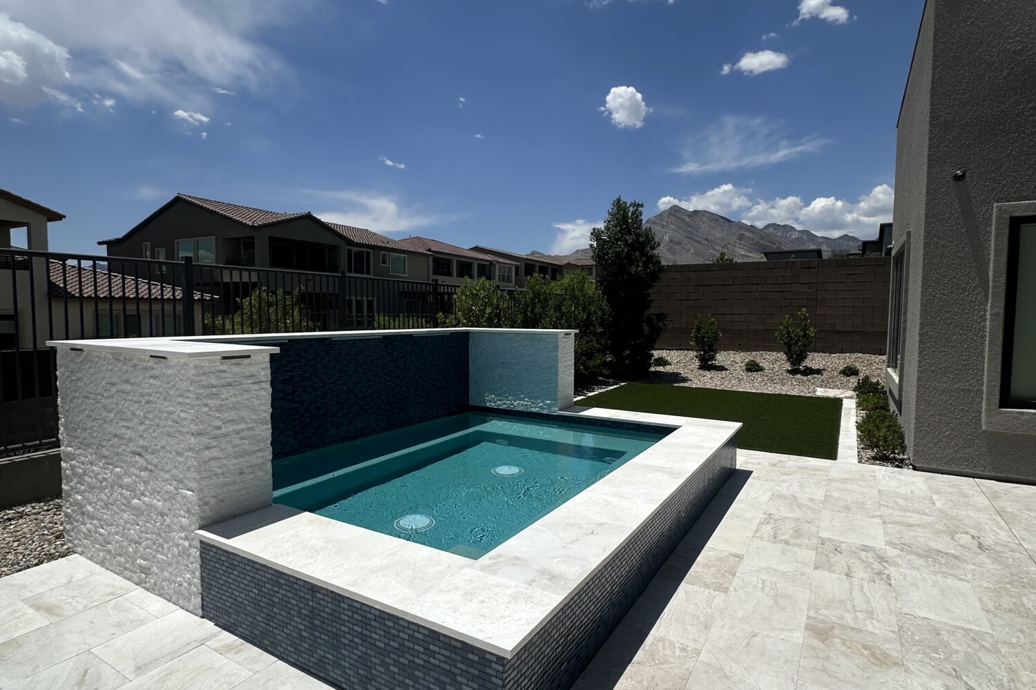Luxury backyard spa installation in Las Vegas by Aqua Creations, featuring custom tile and integrated seating